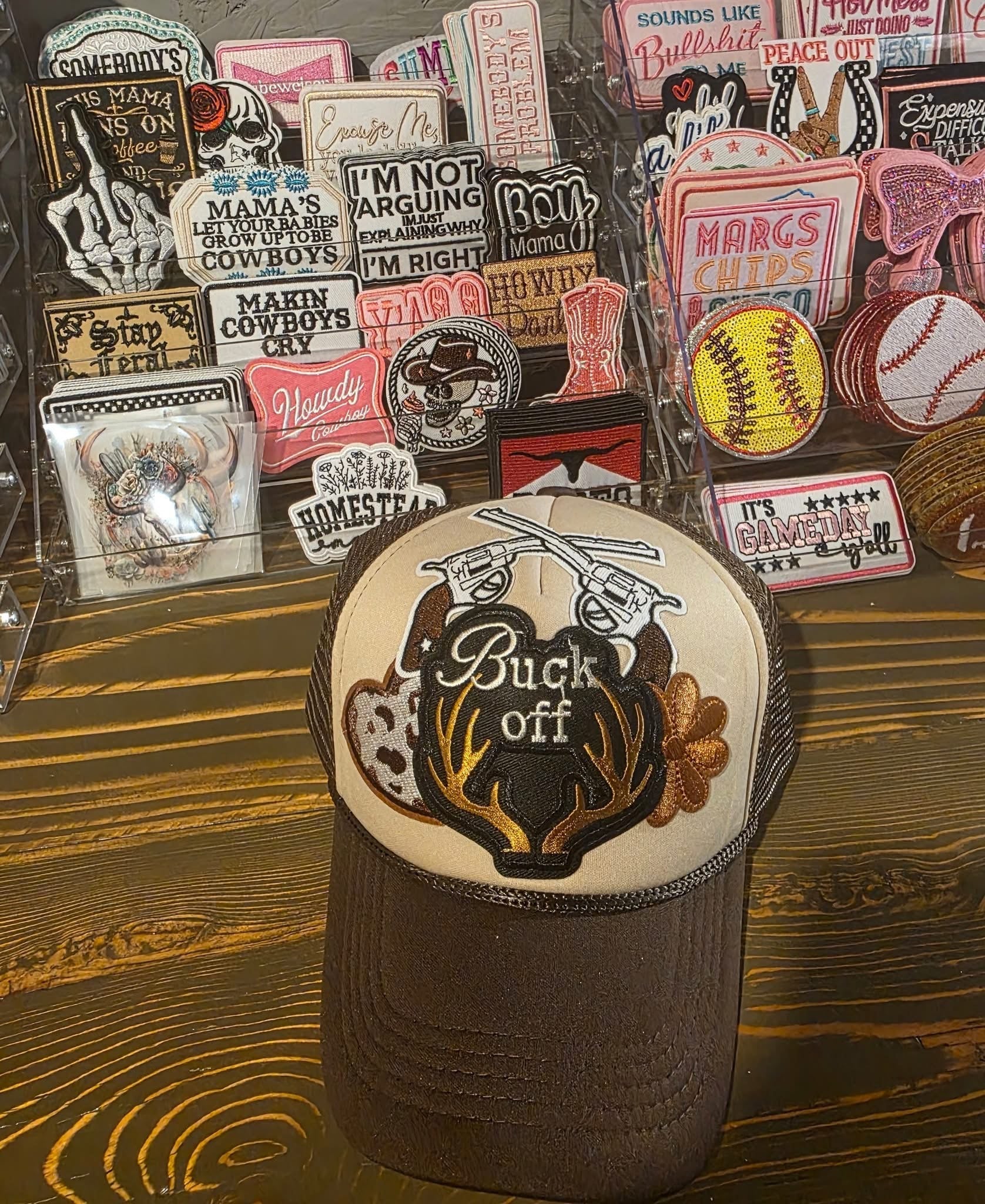Custom trucker hat with Buck Off patch and assorted patches in background